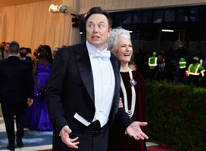 Elon Musk wearing a tuxedo with a white bowtie and waistcoat, making a funny face, walking with his mother 