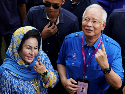 Malaysia's Prime Minister Najib Razak and his wife Rosmah Mansor show their ink-stained fingers after voting in Malaysia's general election in Pekan