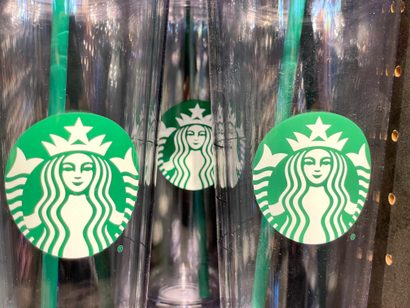 The Starbucks logo is displayed on water cups at a Starbucks store on October 29, 2021 in Marin City, California. Starbucks shares fell 7 percent a day after the coffee chain reported fourth quarter earnings that fell short of analyst expectations. The company also announced plans to raise barista pay by summer of 2022.