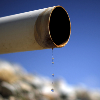 A dry pipe drips water on Gless Ranch in Kern County, California.