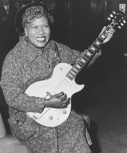Sister Rosetta Tharpe, guitar-playing American gospel singer, gives an inpromptu performance in a lounge at London Airport, following her arrival from New York on November 21, 1957. (AP Photo)