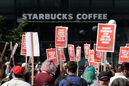 A Starbucks Coffee shop is seen in the background as people gather at Westlake Park during the &quot;Fight Starbucks&#039; Union Busting&quot; rally.