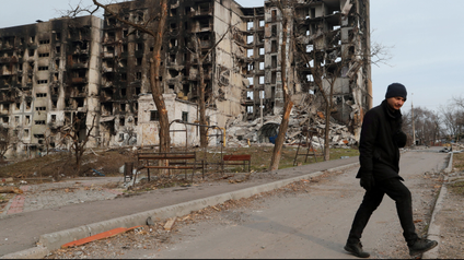 A local resident walks near an apartment building destroyed during Ukraine-Russia conflict in the besieged southern port city of Mariupol, Ukraine March 30, 2022.