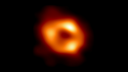 A blurry orange circle is shown in space with a dark black center.