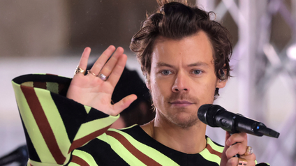 Harry Styles waving during a performance