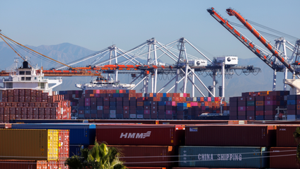 Stacked containers are shown as ships unload their cargo at the Port of Los Angeles in Los Angeles.