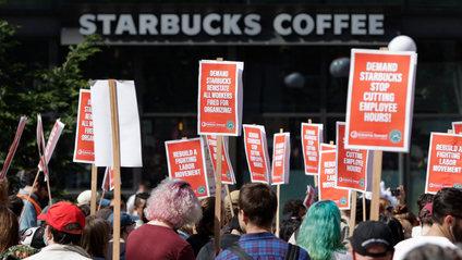 Starbucks protestors holding signs outside a coffee shop