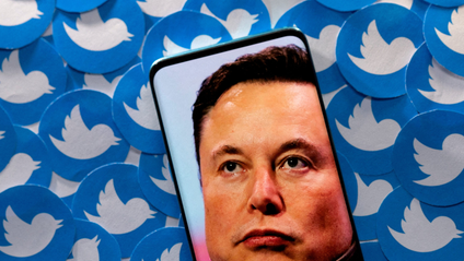 Elon Musk&#039;s face on a phone with Twitter logos