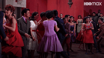 A scene from West Side Story where two groups of dancers are yelling Mambo at each other.