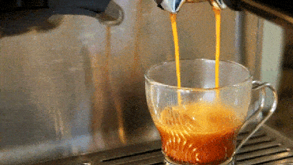 An espresso shot pours into a cup.