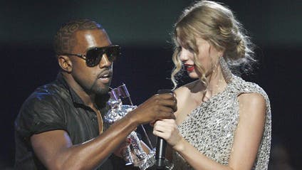 In this Sept. 13, 2009 file photo, Singer Kanye West takes the microphone from singer Taylor Swift as she accepts the "Best Female Video" award during the MTV Video Music Awards on in New York.
