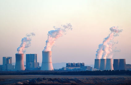 A power plant is pictured with large smoke stacks.