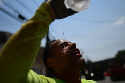 Construction worker Felipe Campuzano pours water on his face to cool off as he digs a sanitation pipe ditch during a heatwave on August 4, 2022 in Philadelphia.