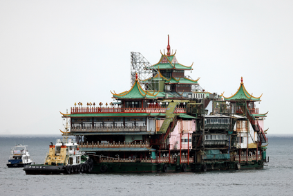Hong Kong&#039;s Jumbo Floating Restaurant being pushed away on the water by tugboats. It&#039;s ornate but looks a little worse for wear.