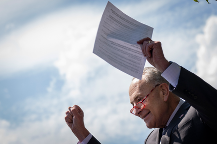 Senate Majority Leader Chuck Schumer holds the Inflation Reduction Act outside the U.S. Capitol
