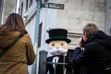 A person dressed as the character "Rich Uncle Pennybags" from Monopoly poses during a photo shoot outside the New York Stock Exchange in New York March 12, 2015.