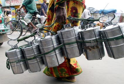 A Bangladeshi woman carries food in tiffin carriers to supply to different shops and offices in Dhaka July 19,2005.