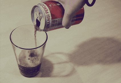 A soda is being poured into a glass.
