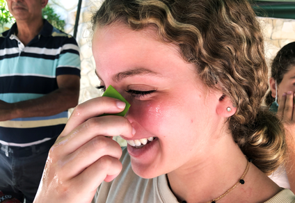 A young woman applies fresh aloe vera gel on her face.