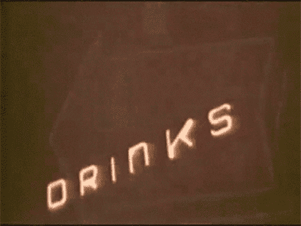 A flashing neon sign that says EAT and DRINKS