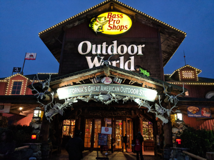 A Bass Pro Shops Outdoor World lit up at night with a sign that says California's Great American Outdoor Store