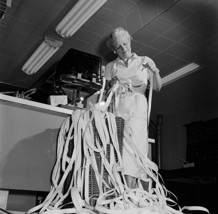 A constant shower of ticker tape emerges from the machine at the Toronto Stock Exchange, giving up-to-date stock quotations.