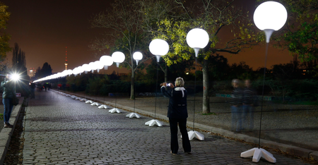 A person takes a photo of the installation &#039;Lichtgrenze&#039; (Border of Light) along a former Berlin Wall location at Mauer Park in Berlin November 7, 2014. A part of the inner city of Berlin is being temporarily divided from November 7 to 9, with a light installation featuring 8000 luminous white balloons, following the 9.5-mile (15.3 kmilometre) path the Berlin Wall once occupied, to commemorate the 25th anniversary of the fall of the Wall. REUTERS/Pawel Kopczynski (GERMANY - Tags: ANNIVERSARY ENTERTAINMENT CITYSCAPE) - RTR4DAUN