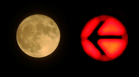 A red traffic light is seen next to the moon in downtown Frankfurt, Germany November 14, 2016.