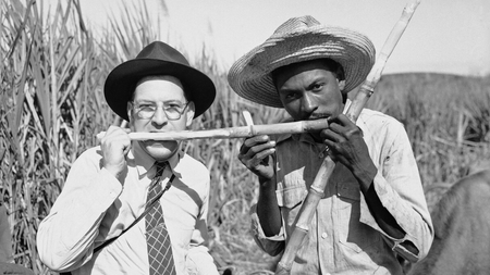 Associated Press Wide World photographer Ken Lucas tries his teeth on a piece of raw sugar cane with a Cuban sugar farmer, Jan. 25, 1946.