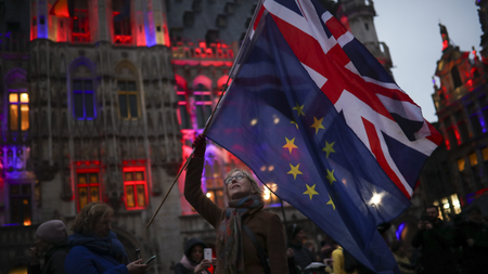 A woman holds up the Union and the European Union flags during an event called &quot;Brussels calling&quot; to celebrate the friendship between Belgium and Britain