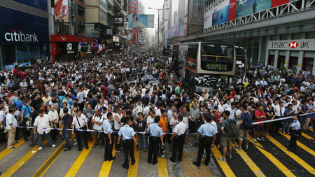 Anti-Occupy Central protesters stand behind a police cordon on Nathan Road at Hong Kong&#039;s Mongkok shopping district October 3, 2014,