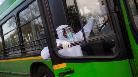 A driver wearing a protective suit climbs a bus used for transporting suspected carriers of coronavirus to a quarantine facility amid concerns about the spread of coronavirus disease (COVID-19), in Nizamuddin area of New Delhi, India, March 30, 2020. REUTERS/Danish Siddiqui