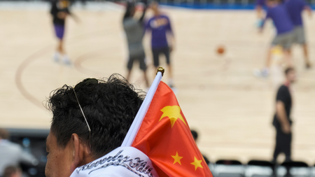 A fan carries a Chinese national flag during an NBA Los Angeles Lakers v Brooklyn Nets game in Shenzhen, China on October 12, 2019.