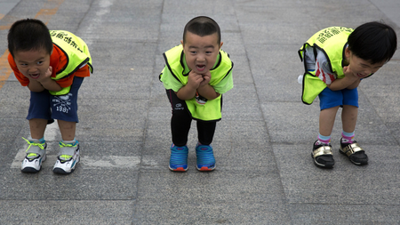 Children practice their postures during a roller blading class outside a park in Beijing, China, Wednesday, June 24, 2015.