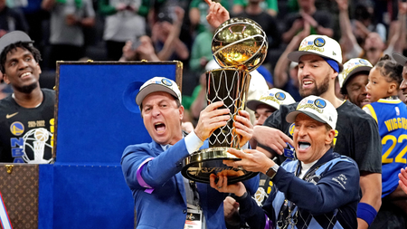 Warriors owners Joe Lacob and Peter Guber hold the 2022 NBA Finals trophy