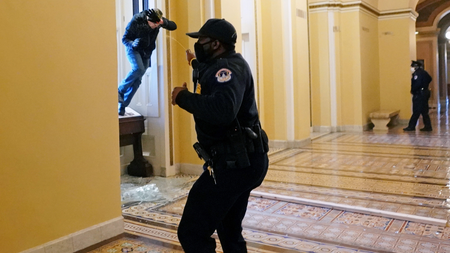 A U.S. Capitol police officer shoots pepper spray at a protestor attempting to enter the Capitol building during a joint session of Congress to certify the 2020 election results on Capitol Hill in Washington, U.S., January 6, 2021.