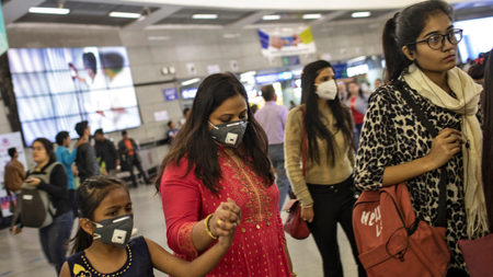 Commuters wearing protective masks rush to board metro trains at a station, amid coronavirus disease (COVID-19) fears, in New Delhi, India, March 13, 2020. REUTERS/Danish Siddiqui