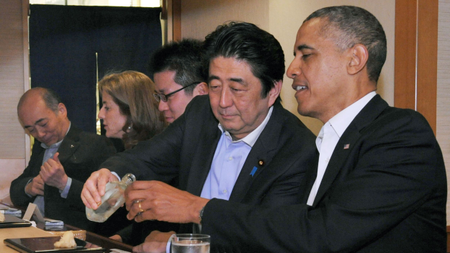 Japanese Prime Minister Shinzo Abe (2nd R) pours sake for U.S. President Barack Obama (R) as they have dinner at the Sukiyabashi Jiro sushi restaurant in Tokyo, in this picture taken April 23, 2014, and released by Japan&#039;s Cabinet Public Relations Office. Obama used a state visit to Japan on Thursday to try to reassure Asian allies of his commitment to ramping up U.S. engagement in the region, despite Chinese complaints that his real aim is to contain Beijing&#039;s rise. Japanese Ambassador to the U.S. Kenichiro Sasae, U.S. Ambassador to Japan Caroline Kennedy and an unidentified interpreter (L-C) sit alongside Abe and Obama. Picture taken April 23. REUTERS/Cabinet Public Relations Office