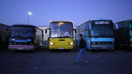 The bus passengers start to wake up as dawn falls at the parking lot outside the customs checkpoint at Khorgos.