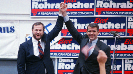 Oliver North, the former Marine lieutenant colonel who faces federal conspiracy charges for his role in the Iran-Contra affair, joins old White House buddy Dana Rohrabacher, candidate for the state&#039;s 42nd Congressional District, at a rally in a hangar at Long Beach, California Airport, June 1, 1988.