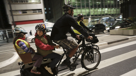 DATE IMPORTED:September 23, 2014A man rides his bicycle as he carries children during World Car-Free Day in Sao Paulo September 22, 2014. REUTERS/Nacho Doce