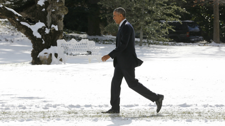President Barack Obama walks in the snow on the South Lawn of the White House in Washington, January 7, 2015.