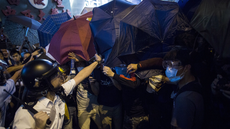 DATE IMPORTED:October 17, 2014A riot policeman takes an umbrella from a pro democracy protester during a scuffle on a blocked road at Mongkok shopping district in Hong Kong October 17, 2014. REUTERS/Tyrone Siu