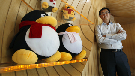 Tencent Chairman and CEO Pony Ma poses with mascots for QQ.com inside the company&#039;s headquarters in Nanshan Hi-Tech Industrial Park in the southern Chinese city of Shenzhen during an interview by Reuters June 9, 2011.