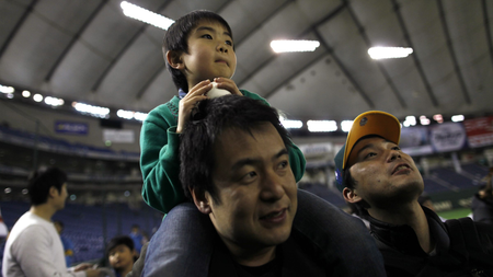 father japan paternity leave parenting parental leave abe shinzo Sota Miki, 6, sitting on his father Yoshihiko&#039;s shoulders watch players after a baseball exhibition game between Oakland Athletics and Yomiuri Giants in Tokyo March 25, 2012. REUTERS/Toru Hanai