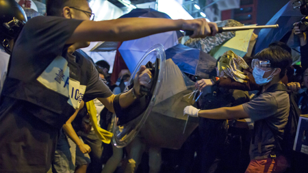DATE IMPORTED:October 17, 2014A riot police officer holds a baton as he confronts pro-democracy protesters on a blocked road at Mongkok shopping district in Hong Kong October 17, 2014.REUTERS/Tyrone Siu