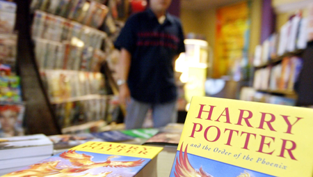 WDA02 - INDONESIA - JAKARTA : An Indonesian man walks passes books of the latest adventures of Harry Potter at a bookstore in Jakarta 24 June 2003.The bespectacled little wizard has also begun casting his spell in Jakarta, as bookstores in the city have each claimed to sell over the weekend an average of 100 copies of the latest adventures of Harry Potter. Nevertheless, some fans are still so curious at the wizard&#039;s latest tale that it has made them browse the Internet to find a draft of the book. However, they have been both disappointed and relieved to discover that the Internet version is a fake. EPA PHOTO/WEDA