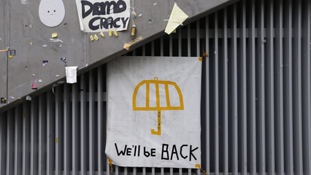 A poster of an umbrella with the words &quot;We&#039;ll be back&quot; written underneath is pictured on a wall at the main &quot;Occupy&quot; protest site at Admiralty in Hong Kong