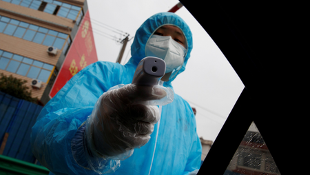 Photo of medical worker with temperature gun