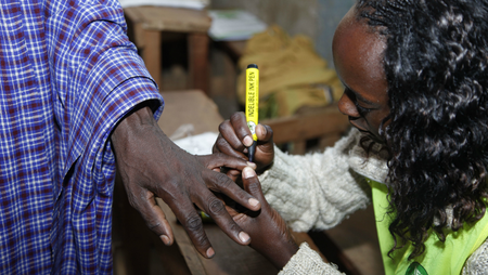An official at the polling station put an ink mark on a Masai finger after he cased his vote.